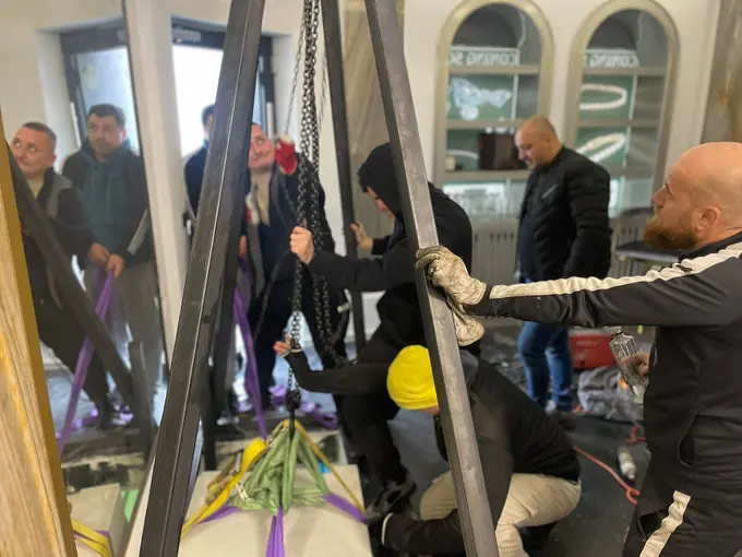 Echipă la manipularea unui obiect greu cu dispozitive de ridicare